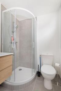 a bathroom with a white toilet and a shower at Elégant Flat Paris CDG Expo in Aulnay-sous-Bois +6 photos