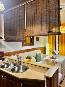 cocina con fregadero y sofá en Casa Rural Abril, en Setenil