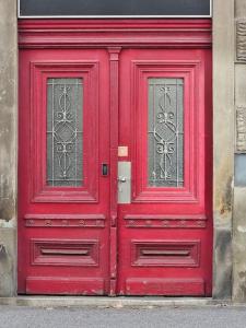 una puerta roja con dos ventanas en un edificio en Old city life, en Maribor