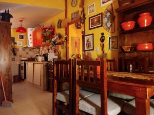 a kitchen with yellow walls and a wooden table and a kitchen with a counter at El REFUGIO DE KARIM in San Rafael