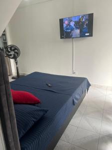 a bed in a room with a tv on the wall at ApartaTour-comuna trece in Medellín