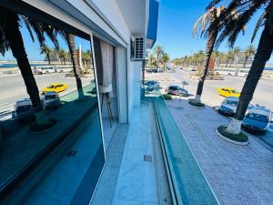 a building with palm trees and a view of a street at BATUU Luxury Living SEA FRONT in Bizerte