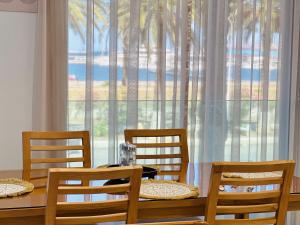 a dining room with a table and chairs and a large window at BATUU Luxury Living SEA FRONT in Bizerte