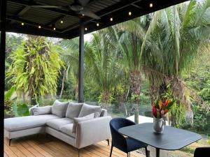 a living room with a couch and a table at Ruca Lodge - Luxury Container Tiny Home Surrounded by Nature in Uvita