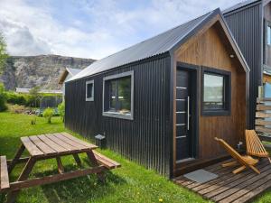 a black tiny house with a wooden deck at Patagonia Tiny House in El Chalten