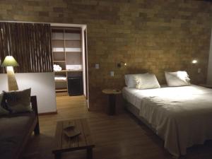 una camera d'albergo con un letto e un divano di Chalés na Vila Natholi a Imbassai