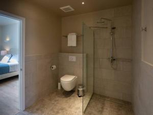 a bathroom with a shower and a toilet and a bed at Dutch Caribbean Residence C in Palm-Eagle Beach +17 photos