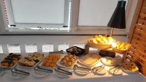 a table filled with different types of pastries and desserts at Pousada Jangadeiro in Porto Seguro +27 photos