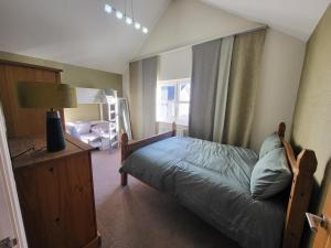 a bedroom with a bed with a lamp and a window at Anchor Gardens Villa in Lindal in Furness