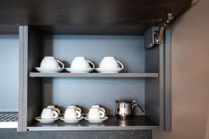 - une étagère avec des tasses et des théières dans la cuisine dans l'établissement N-149 Luxury Apartments, à Bari 22 autres photos