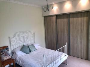 ein Schlafzimmer mit einem weißen Bett mit blauen Kissen in der Unterkunft Cheerful 2 bedroom town house in Lancashire in Chorley + 23 Fotos
