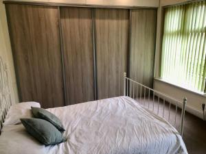 ein Schlafzimmer mit einem Bett mit zwei Kissen darauf in der Unterkunft Cheerful 2 bedroom town house in Lancashire in Chorley