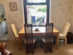 ein Esstisch mit Stühlen und ein Fenster in der Unterkunft Cheerful 2 bedroom town house in Lancashire in Chorley