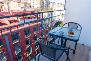 a table and chairs on a balcony with a view of a city at NA bella vista Rooftop-B&B in Naples
