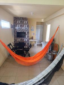 eine orangefarbene Hängematte in einem Zimmer mit Esszimmer in der Unterkunft Casa Müller - Veraneio Imbé in Imbé