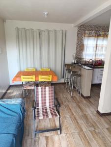 ein Zimmer mit Tisch und Stühlen und eine Küche in der Unterkunft Casa Müller - Veraneio Imbé in Imbé + 3 Fotos