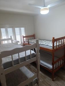 zwei Etagenbetten in einem Zimmer mit Fenster in der Unterkunft Casa Müller - Veraneio Imbé in Imbé