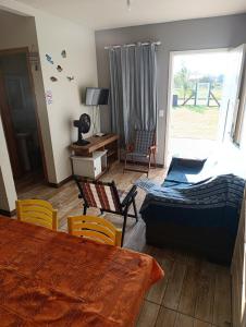 ein Schlafzimmer mit einem Bett und einem Tisch und Stühlen in der Unterkunft Casa Müller - Veraneio Imbé in Imbé