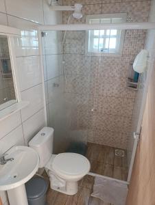 ein Badezimmer mit Dusche, Toilette und Waschbecken in der Unterkunft Casa Müller - Veraneio Imbé in Imbé