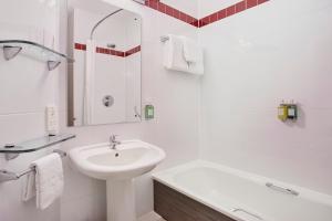 a white bathroom with a sink and a bath tub at Leonardo Hotel Plymouth - Formerly Jurys Inn in Plymouth