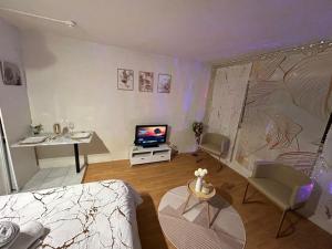 a living room with a couch and a tv at Nid Dor avec Parking in Carquefou