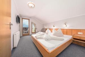 a bedroom with a large bed with white pillows at das Huber in Mayrhofen