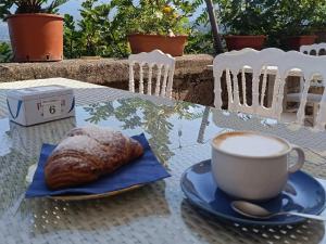 a cup of coffee and a croissant on a table at B&B Sunset Suite Belvedere in Sant'Agata de' Goti