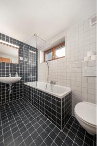 a bathroom with a tub and a sink and a toilet at das Huber in Mayrhofen