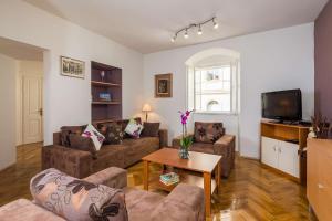 een woonkamer met 2 banken en een tv bij Apartment See Everlasting Split in Split