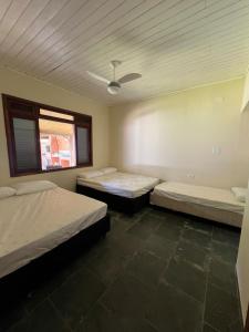 a room with two beds and a window at Casa na praia do Guaiuba in Guarujá