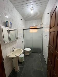 a bathroom with a sink and a toilet and a shower at Casa na praia do Guaiuba in Guarujá