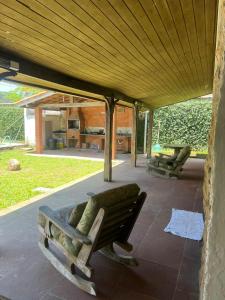 eine Veranda mit einer Bank unter einem Holzdach in der Unterkunft Casa na praia do Guaiuba in Guarujá