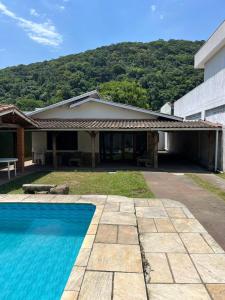 ein Haus mit einem Swimmingpool vor einem Gebäude in der Unterkunft Casa na praia do Guaiuba in Guarujá