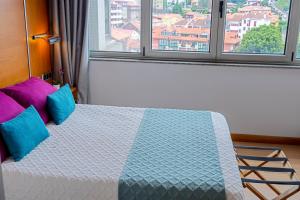 康达Hotel Faranda Marsol Candas, Ascend Hotel Collection的一间卧室配有一张带蓝色和紫色枕头的床 更多37张照片