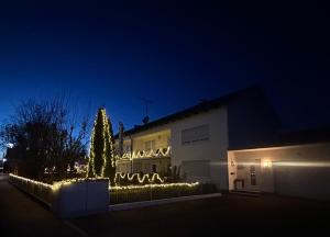 un sapin de Noël illuminé devant un bâtiment dans l'établissement Oase1 mit Parkplatz, Automatische Kaffeemaschine und Küche, à Untermeitingen
