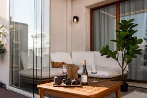 un soggiorno con divano bianco e tavolo con bicchieri da vino di Catalog Boutique Rooms Bratislava a Bratislava Altre 46 foto