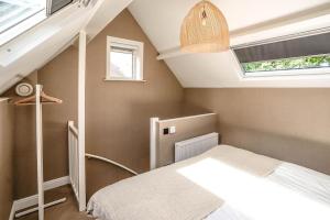 1 dormitorio en el ático con cama y ventana en Haya Beachhouse - King, en Scheveningen