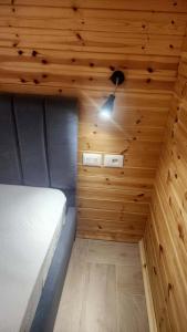 a small room with a bed in a wooden ceiling at UniKlajd Villa-s in Golem