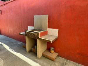 eine Bank, die neben einer roten Wand sitzt in der Unterkunft Casa en Pesquería NL, cerca del Aeropuerto de Monterrey in Villa Juárez + 7 Fotos
