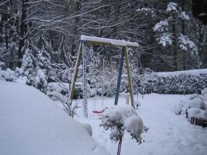 eine Schaukel in einem schneebedeckten Hof in der Unterkunft Dachstudio Sternenblick in Bad Münstereifel