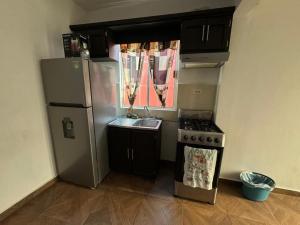 eine Küche mit einem Kühlschrank aus Edelstahl und einer Spüle in der Unterkunft Casa en Pesquería NL, cerca del Aeropuerto de Monterrey in Villa Juárez