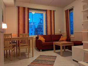 a living room with a couch and a table at RöhköStar 107 in Äkäslompolo