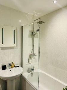 a bathroom with a shower and a sink and a tub at Apartment with Balcony near Chatham Dockside in Brompton