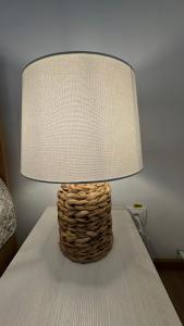 una lámpara sobre una cama con una mesa en Simonette Maisonette - Mountain Retreat, en Buşteni