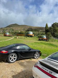 a black car parked next to a field with tents at Glamping Brillo de Luna in Guatavita +2 photos
