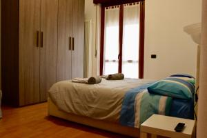 a bedroom with a bed and a large window at Pietro Apartment Fiera in Lainate