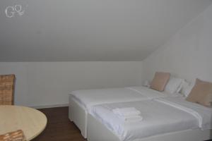 a white bed in a room with a table at GQ Deluxe Apartment in Saarbrücken