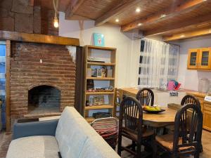 a living room with a table and a brick fireplace at Cabañas Misión Amealco in Amealco