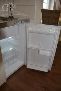 a white refrigerator with its door open in a kitchen at GQ Deluxe Apartment in Saarbrücken