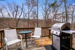 a grill and chairs on a deck with a table at Huckleberry Ridge at Massanutten in McGaheysville